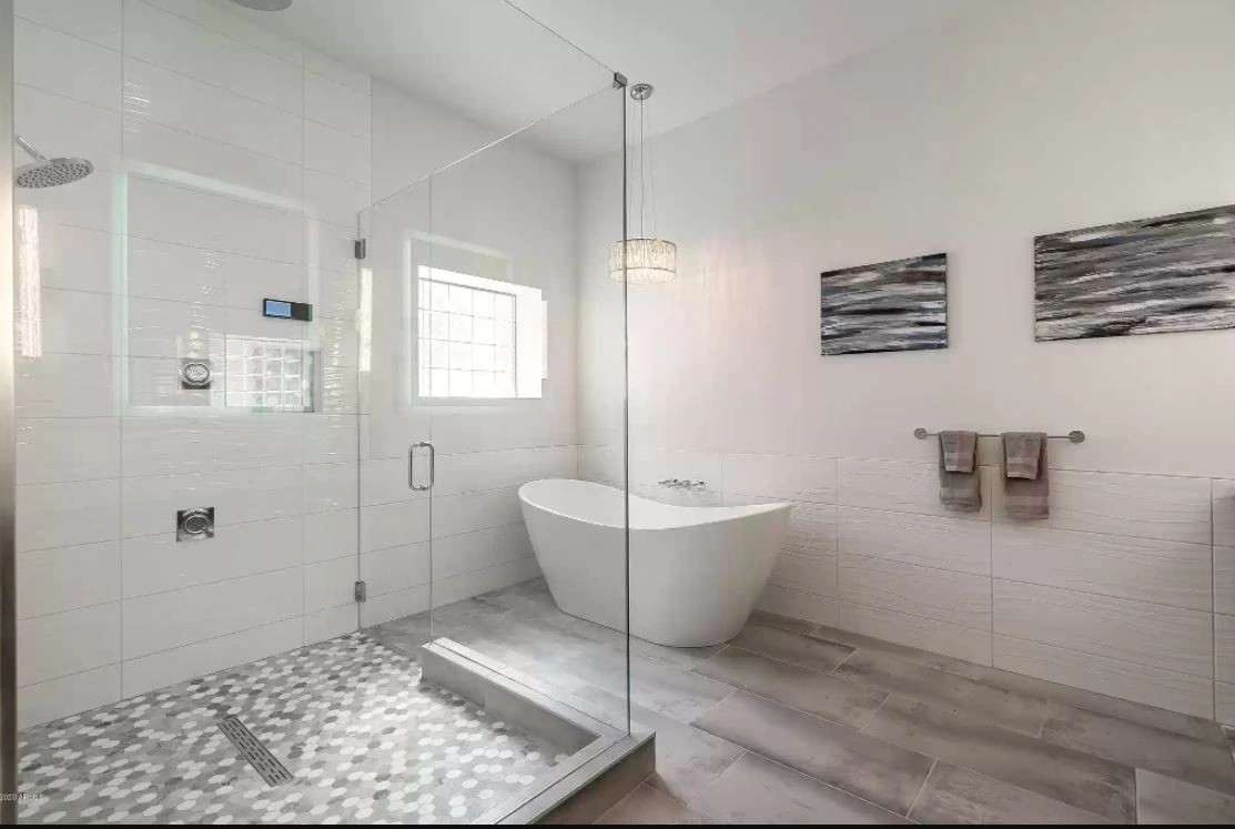 A second bathroom in the same house with a stained wood vanity, granite counter and framed mirrors